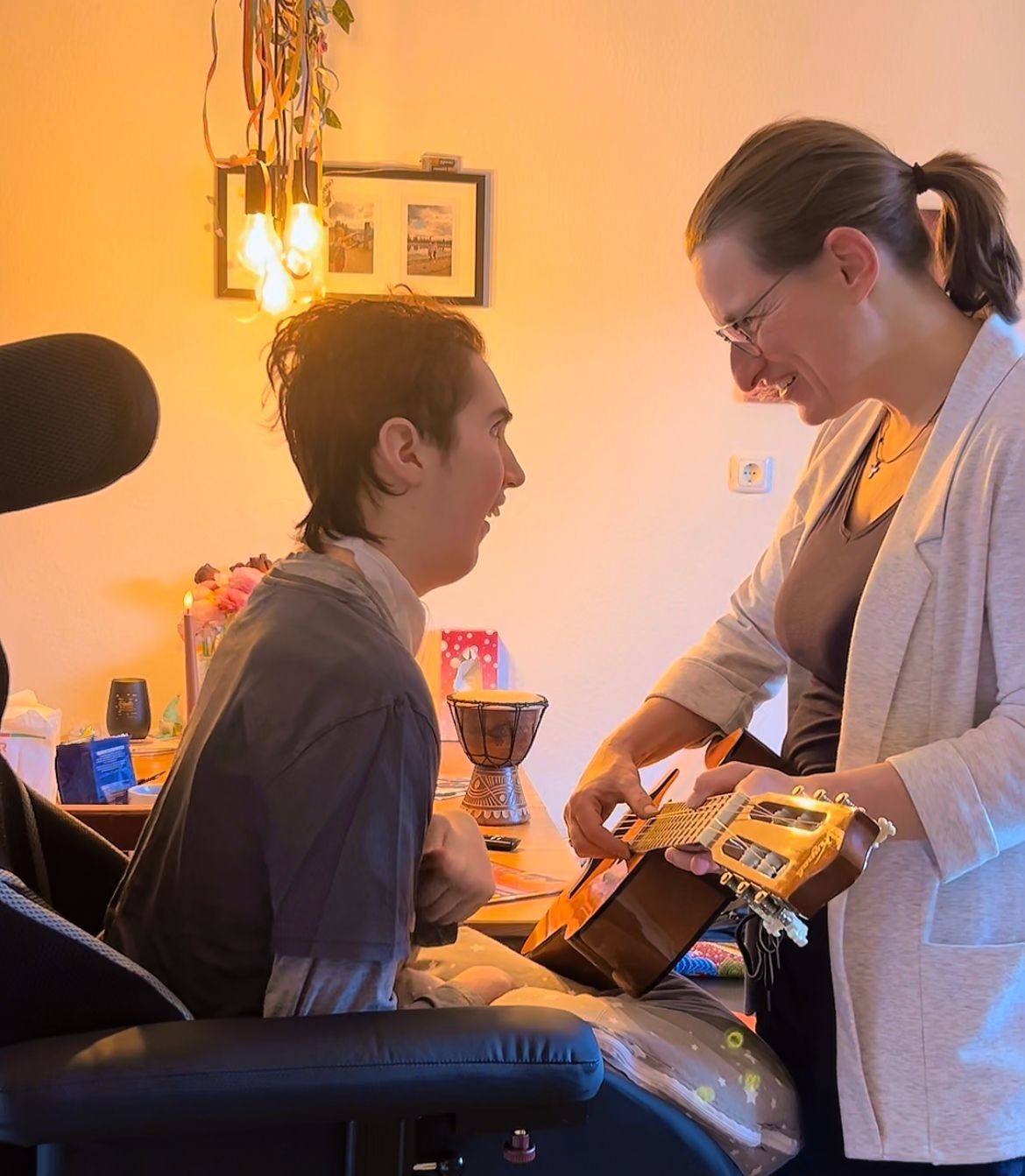 „Claudia begleitet einen Klienten mit Gitarre in der Musiktherapie.